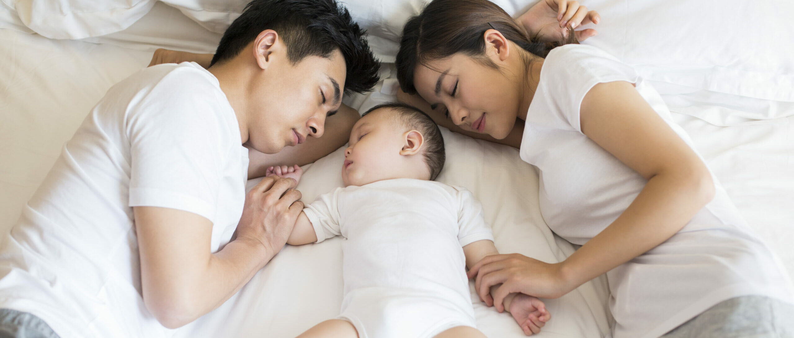 Mother and Father Sleeping with a Baby